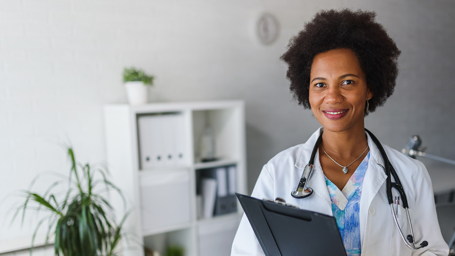 a photo of a smiling doctor standing in an office
